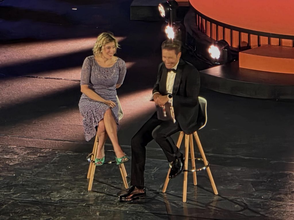 L'attrice Valeria Bruni Tedeschi e il conduttore Massimiliano Ossini seduti sul palco del Teatro Antico di Taormina durante il Gala di Taobuk.